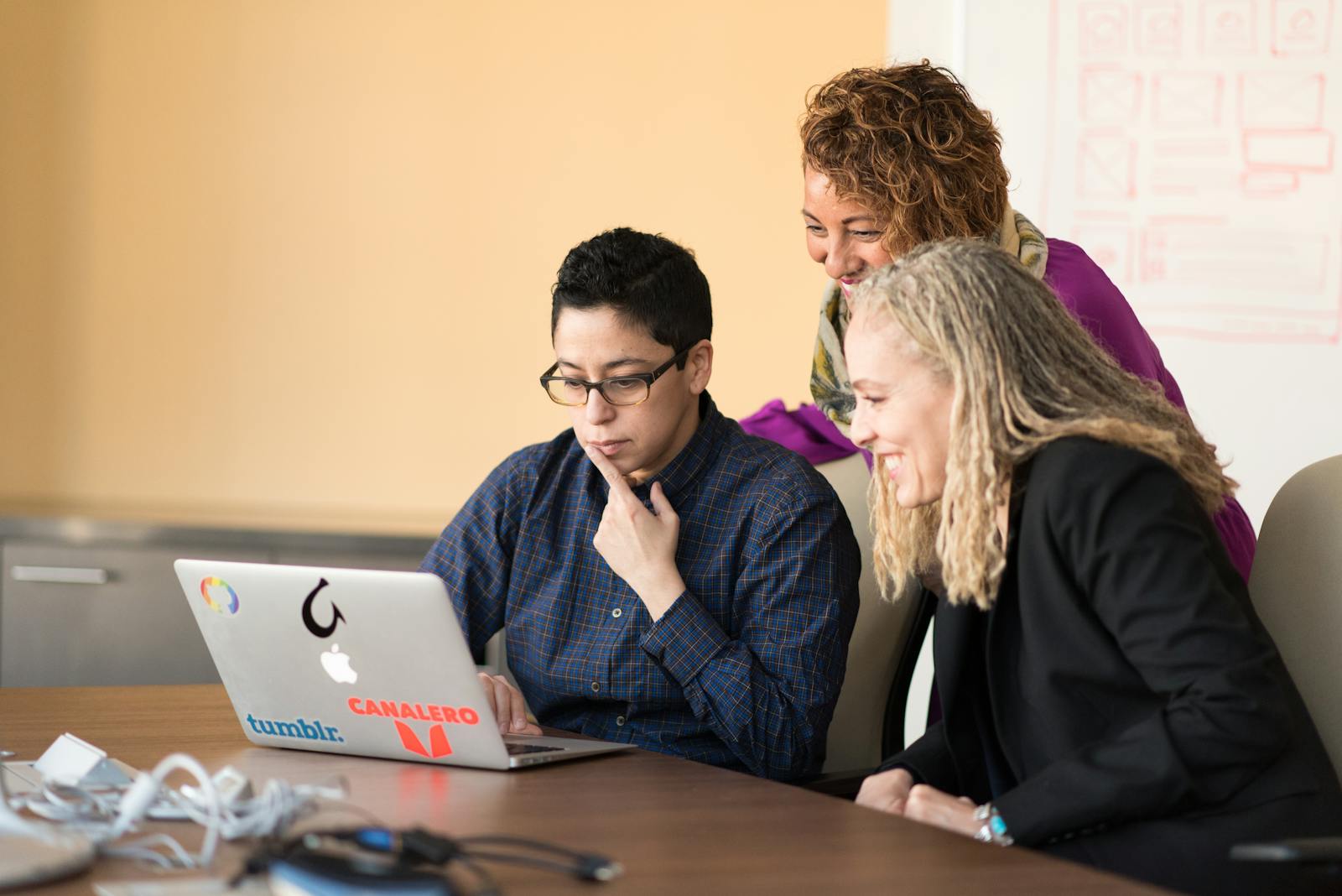 Photo by Christina Morillo Three colleagues working together on a laptop, fostering teamwork and innovation.