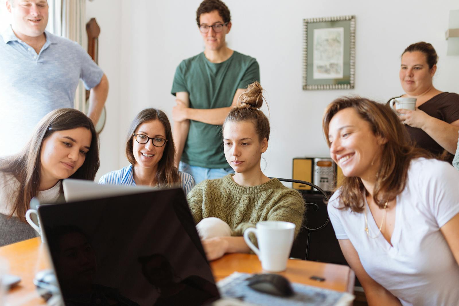 Photo by Fox A diverse group of adults at work, enjoying a casual meeting indoors with focus and smiles.